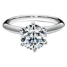 a white gold engagement ring with a round brilliant cut diamond in the center, set on an 18k white gold band