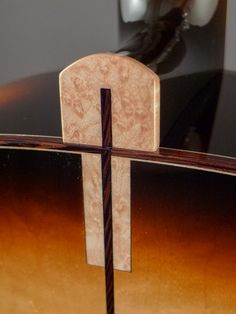 an acoustic guitar with a wooden cross on it