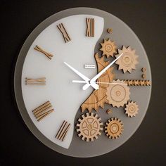 a clock made out of wooden gears on a black surface with white hands and numbers