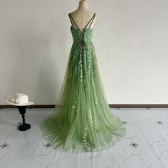 a green dress on display in front of a white wall