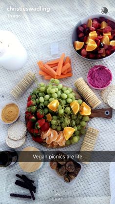 a platter filled with fruits and veggies on top of a white table cloth