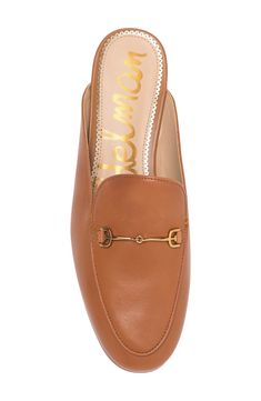 A glittery scalloped insole trim adds dainty style to this sleek mule that has brassy goldtone hardware and a subtle heel. Synthetic or leather upper and lining/rubber sole Imported Classic Low Heel Mules With Branded Insole, Classic Mules With Branded Insole And Low Heel, Chic Mules With Leather Footbed And Almond Toe, Chic Mules With Almond Toe And Leather Footbed, Chic Almond Toe Leather Mules, Gold Slip-on Mules For Work, Gold Mules For Spring Workwear, Spring Heels With Gold-tone Hardware, Elegant Low Heel Mules For Fall