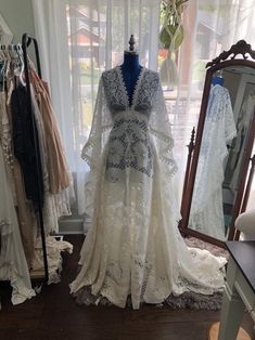 a dress is displayed in front of a mirror and other dresses are on the floor