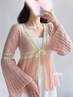 a woman in a white dress and pink cardigan is taking a selfie with her cell phone