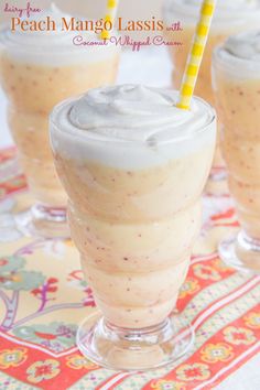 three glasses filled with ice cream sitting on top of a colorful table cloth next to each other