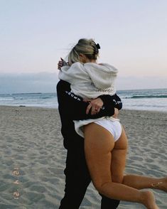 a man holding a woman on the beach