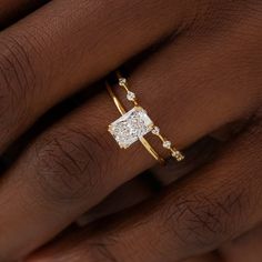 a woman's hand with a gold ring and diamond set on top of her finger