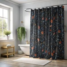 a bathroom with a bathtub, rug and shower curtain that has flowers on it