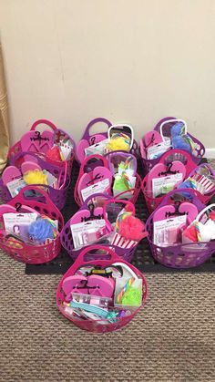 a pile of pink baskets filled with lots of items on the floor next to a wall