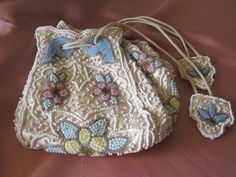 EXTRAORDINARY ANTIQUE DRAWSTRING Beaded Bag  Perfect for your private collection,  vintage wedding, photo shoot or a museum!  I was fortunate enough to purchase this stunning piece in the North Carolina mountains.Label says MADE IN JAPAN which dates it after 1921. The bag is made of ivory satin with thousands of tiny white, blue, pink and yellow glass beads. Beautifully made in a floral pattern. The lining is a matching satin ivory and very clean. The base measures 5 X 5 inches with a height of Antique Handmade Wedding Bags, Victorian Handmade Wedding Bags, Vintage Cream Bags For Weddings, Vintage Cream Bag For Wedding, Vintage Beaded Bags For Gifts, Antique Beaded Wedding Bag, Antique Beaded Wedding Bags, Vintage Handmade Wedding Bags, Vintage Cream Bag For Gift