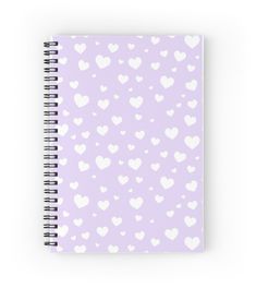 a spiral notebook with white hearts on a lila background, in the shape of heart shapes