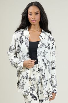 Nothing completes the look, like Another Day In Paradise Tropical Print Oversized Button Down Shirt! It features a classic collar with functional buttons along the center front. Maintains an oversized fit with a slight drop shoulder and elongated hem. Layer it over a ribbed tank and the matching pants! - Functional buttons- Button cuffs- Oversized- Drop shoulder- Color: White BlackSize + Fit - Model is 5'8" and wearing size XS- Measurements taken from size S - Chest: 24"- Length: 30" Fabric Self White Button-up Top For Loungewear, Oversized White Blouse With Button Closure, Oversized Vacation Shirt, White Camp Collar Shirt For Loungewear, Oversized Button-up Shirt For Loungewear, Effortless White Button-up Blouse, Oversized Loungewear Blouse With Button Closure, Oversized Blouse For Loungewear With Button Closure, White Button Closure Blouse For Loungewear