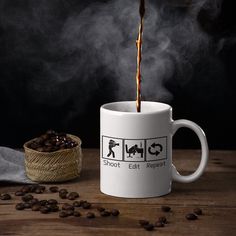 coffee being poured into a mug with the words shoot, eat, repeat on it