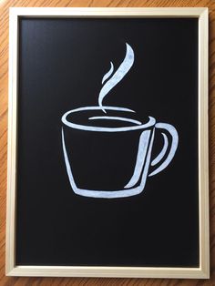 a cup of coffee is drawn on a blackboard with white chalk in the frame