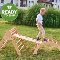 a young boy playing on a wooden playground set