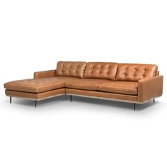 a tan leather sectional sofa with metal legs and footrests on an isolated white background