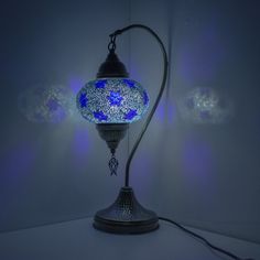 a lamp that is lit up in the dark with blue lights around it and on top of a table