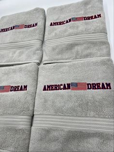 towels with american dream embroidered on them are lined up in a row and stacked next to each other