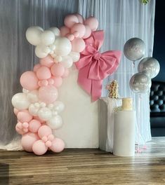 a balloon arch with pink and white balloons