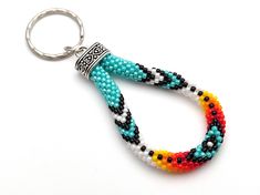 a beaded keychain is shown on a white surface with a metal ring