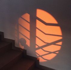 the shadow of a person standing in front of a light that is on top of some stairs