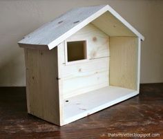 a small wooden birdhouse sitting on top of a wood floor next to a wall