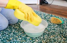 a woman cleaning the floor with a yellow glove