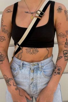 a woman with many tattoos on her body and chest is standing in front of a garage door