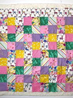 a colorful patchwork quilt hanging on the wall