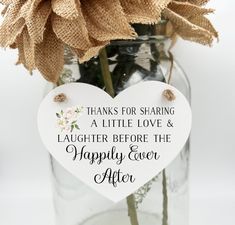 a heart shaped sign hanging from a vase filled with flowers