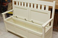 a white wooden bench with storage underneath it