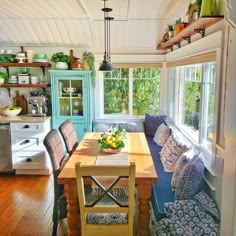 a kitchen with a table, couch and window in the middle of it's room