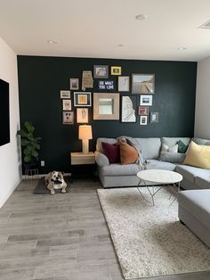 a living room filled with lots of furniture and pictures on the wall above the couch