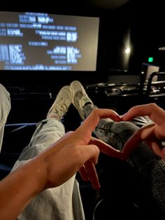 two people sitting in front of a projector screen with their hands on the ground