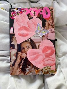 a magazine cover with pink paper hearts and butterflies on it's side, sitting on a bed