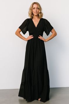 Baltic Born exclusive style Solid black color Lightweight, flowing chiffon material Surplice neckline Flutter sleeves Keyhole at back neck Waist detail with attached ties at sides Angled tiered maxi skirt Midi length lining 100% Polyester Trina is 5'6, cup size 32D, size 2 and is wearing size S Baltic Born, Tiered Maxi Skirt, Maxi Dress Black, Surplice Neckline, Skirt Midi, Chiffon Material, Cup Size, Flutter Sleeves, Black Maxi Dress