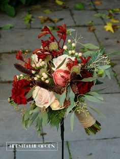 a bouquet of flowers is sitting on top of a pole in front of a brick walkway