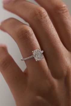 a woman's hand with a diamond ring on top of her finger and an engagement band