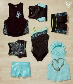 an assortment of swimsuits and shorts laid out on a wooden floor with hearts drawn on them