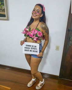 a woman with pink flowers on her chest holding a sign