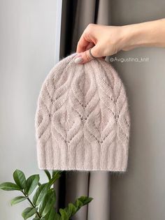 a hand is holding up a knitted hat