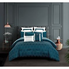 a bed room with a neatly made bed and blue comforter set on the floor