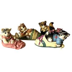 three small figurines of cats sitting on top of each other, one in the shape of a shoe