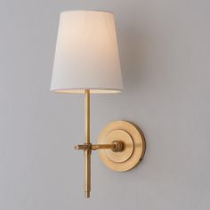 a wall light with a white shade on it's side and a gray background