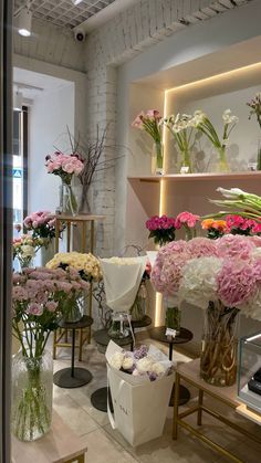 the flowers are in vases on display at the flower shop's storefront