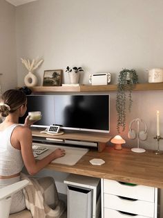 a woman sitting at a desk holding a cup