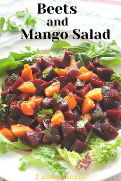 beets and mango salad on a plate with lettuce, carrots and cilantro