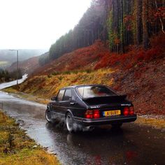 a black car driving down a wet road