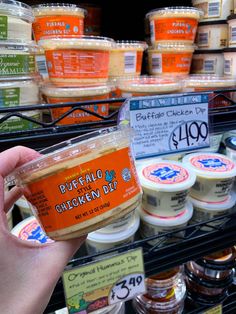 a person holding up an ice cream in front of some shelves