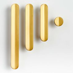 three brass knobs on a white surface